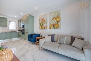 a living room with a couch and a kitchen at Central Malta Gem - 3BR Apartment with Balconies in Mosta