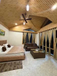a bedroom with a bed and a ceiling fan at Tulip Flowing River View Hotel. in Shamshi
