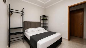 a bedroom with a bed with a black and white comforter at Apto central ideal para casais e famílias em Foz 3 in Foz do Iguaçu