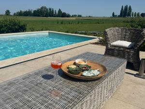 a table with a plate of food and a glass of wine at Tyne View Hideaway in Zonnebeke