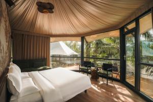 a bedroom with a white bed and a balcony at Seawind Cloudcrest Resort in Semporna