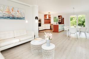a white living room with a couch and a table at Haus Sommerzeit in Fissau