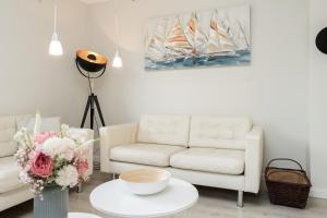 a living room with a white couch and a table at Haus Sommerzeit in Fissau