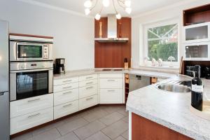 a kitchen with white cabinets and a sink and a window at Haus Sommerzeit in Fissau