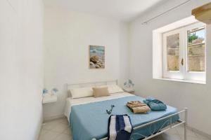 a bedroom with a bed with blue sheets and a window at Casa Gio & Angie in Forio d'Ischia +24 photos