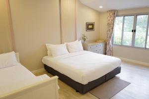 a bedroom with two beds and a window at Mazecape in Ban Hua Khwai