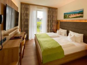 a hotel room with a bed and a television at Dorf Hotel Grüner Baum in Maria Laach am Jauerling