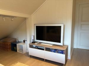 a flat screen tv sitting on a stand in a room at Loftsrom in Drammen