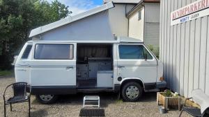 a white van parked next to a building at Sleep inside a classic Volkswagen Westfalia or our legendary Mercedes Düdo overland cabin in central Svolvær Close to public showers and toilets NO PARKING in Svolvær