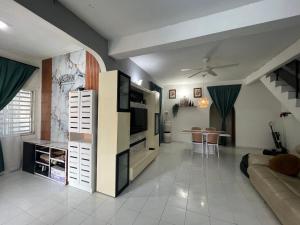 a living room with a tv and a couch and a table at wawa homestay in Butterworth +14 photos