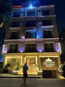 a man standing in front of a building at night at Aziz Egypt Hotel in Cairo