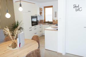 a kitchen with a wooden table with chairs and a counter at Riverhaus in Schladming +16 photos