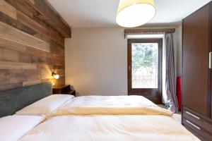 a bedroom with two beds and a window at Appartamento Petit Flower in Valdidentro