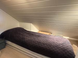 a bed in a room with a ceiling at Loftsrom in Drammen