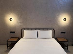 a bedroom with a white bed with two tables at AiTumar boutique hotel in Almaty