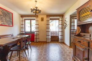 a dining room with a wooden table and chairs at Appartamento Petit Flower in Valdidentro +36 photos