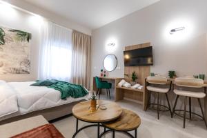 a bedroom with a bed and a table and chairs at Breeze Apartments Megara - Echo in Megara