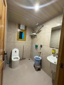 a bathroom with a toilet and a sink at Tulip Flowing River View Hotel. in Shamshi +48 photos