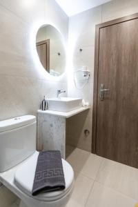 a bathroom with a toilet and a sink and a mirror at Breeze Apartments Megara - Echo in Megara
