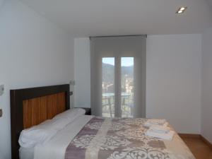 a bedroom with a bed and a balcony at Puerta de Ordesa Garden in Laspuña
