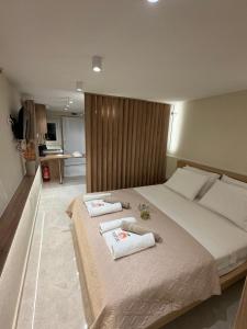 a bedroom with a large bed with towels on it at MANDARIN Luxury Suites in Asprovalta