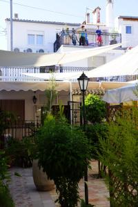 a building with white umbrellas and people on a balcony at Apartamentos Turisticos Ca Ramon in Beniarrés