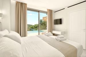 a white bedroom with a bed and a large window at Meliora Exclusive Villas Parga in Parga +106 photos