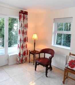a chair and a lamp in a room with windows at Ballyvoy Camping Barn in Willenhall