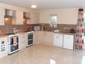 a large kitchen with white appliances in a room at Ballyvoy Camping Barn in Willenhall
