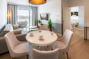 a living room with a couch and a table and chairs at Happy Land Aqua Polanki B405 in Kołobrzeg