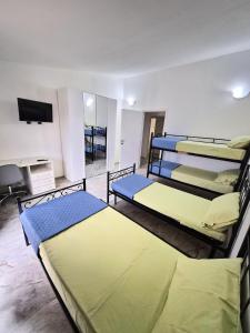 a room with three bunk beds and a flat screen tv at House Manu in Assemini
