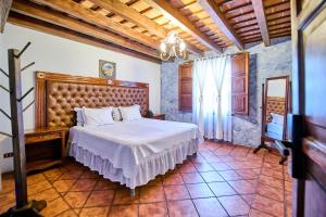 a bedroom with a bed and a chandelier at Hotel El Descanso Cultural in Antigua Guatemala +13 photos
