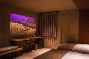 a hotel room with a bed and a desk with a monitor at SABLIER by R HOTEL in Osaka