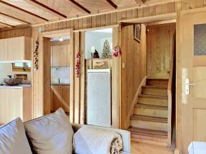 a living room with a couch and a staircase in a tiny house at Chalet Mutzli by Interhome in Agettes