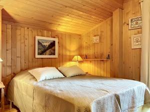 a bedroom with a bed in a wooden room at Chalet Mutzli by Interhome in Agettes
