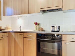 a kitchen with wooden cabinets and a stove top oven at Chalet Mutzli by Interhome in Agettes +13 photos
