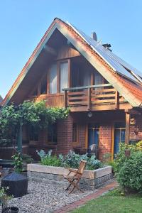 a wooden house with a deck on the side of it at Ferienwohnung Am Spröckel in Bleckede +4 photos