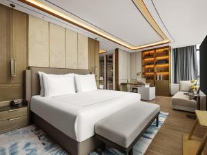 a bedroom with a large bed and a living room at Swissotel Beijing Hong Kong Macau Center in Beijing
