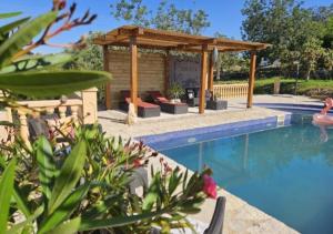 a swimming pool with a gazebo next to a house at Garden Suite Vila Girasoles in Cálig
