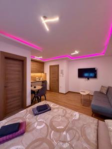 a living room with pink lights on the ceiling at Taca 2 - Airport apartman in Surčin