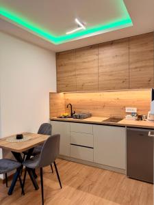 a kitchen with a table and chairs in a room at Taca 2 - Airport apartman in Surčin