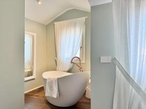 a bathroom with a white tub and a window at B&B Carmen Garden in Burano +45 photos