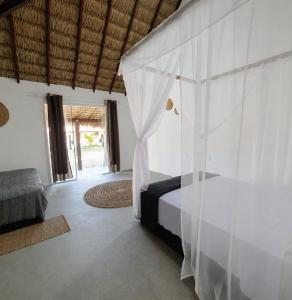 a bedroom with a bed with a canopy at ArpoadorBangalôparaísoperdido in Tutóia