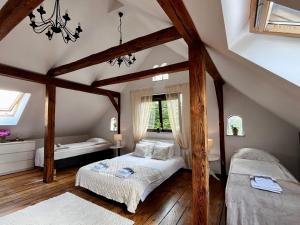 a attic bedroom with two beds and a chandelier at Żuławski Dom in Nowy Dwór Gdański