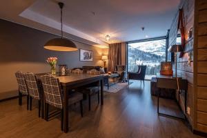 a dining room with a table and chairs and a living room at Skistar Lodge Hemsedal in Hemsedal