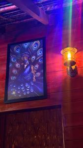 a painting of a peacock on a wall with a light at Wonderful Hostel Trincomalee in Trincomalee