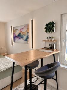 a dining room with a wooden table and two stools at Apartment am Innenstadtwall in Stadthagen