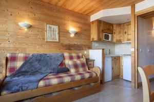 a living room with a couch and a kitchen at Résidence les Cimes - Centre Val d'Isère in Val-d'Isère