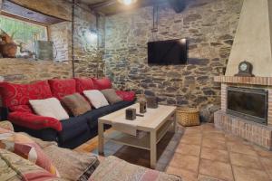 a living room with a couch and a fireplace at Ribera del Cantero in Ponferrada