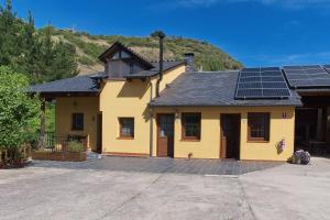 a yellow house with solar panels on the roof at Ribera del Cantero in Ponferrada